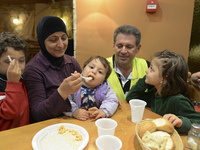 Familiy of refugees from Syria enjoys their Family Evening Meal at the Aspa Boomerang Restaurant, observed by the restaurant owner Michael P...