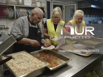 International volunteers from all artound the worl are preparing meals inside of the Aspa Boomerang Restaurant, as the owner Michael Pastrik...