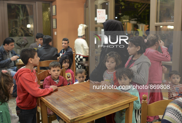 Familiy of refugees from Syria await for their Family Evening Meal at the Aspa Boomerang Restaurant, as the restaurant owner Michael Pastrik...