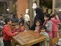 Familiy of refugees from Syria await for their Family Evening Meal at the Aspa Boomerang Restaurant, as the restaurant owner Michael Pastrik...