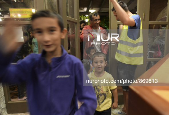 Happy young refugees enter to the Aspa Boomerang Restaurant, as the owner Michael Pastrikos, helped by his family members, his staff and man...