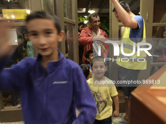 Happy young refugees enter to the Aspa Boomerang Restaurant, as the owner Michael Pastrikos, helped by his family members, his staff and man...
