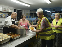 Volunteers from all over the world help at the Aspa Boomerang Restaurant, as the owner Michael Pastrikos, provides free meals for refugees a...