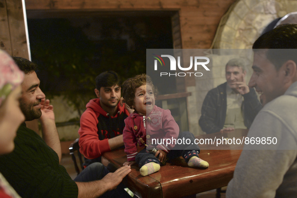 Families of refugees awaiting to enter to the Aspa Boomerang Restaurant, as the owner Michael Pastrikos, helped by his family members, his s...