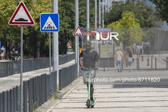 A man is seen riding a scooter in the area around the Tejo river promenade in Oriente. Lisbon August 23, 2022. Portugal recorded another wee...