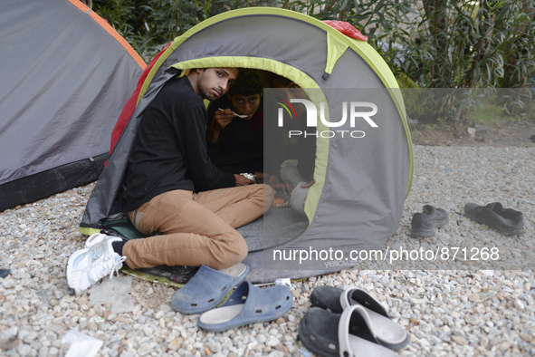 Three migrants from Pakistan having an evening meal in their small tant, near the main Police station in Kos Town, as hundreds of new arrive...