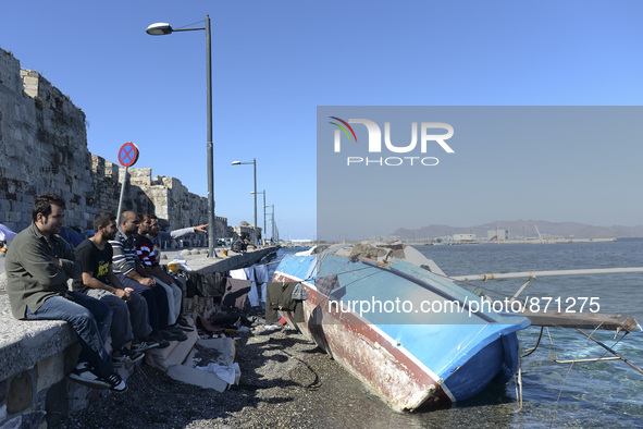 Migrants sitting in Kos harbour. Hundreds of new arrived migrants awaiting on a daily basis to be processed by the Greek police and given pa...