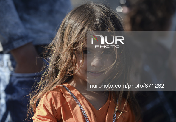 A young Fariba (age 3) from Afganistan, pictured in Kos harbour, as her family awaiting to be processed by the Greek police and given paperw...