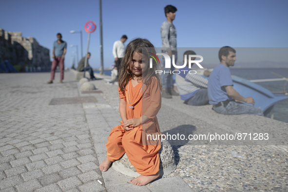 A young Fariba (age 3) from Afganistan, pictured in Kos harbour, as her family awaiting to be processed by the Greek police and given paperw...