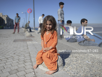 A young Fariba (age 3) from Afganistan, pictured in Kos harbour, as her family awaiting to be processed by the Greek police and given paperw...