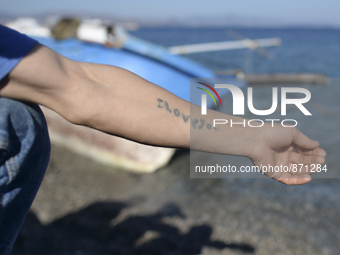 'ILOVEYOU' tatoo on a ram of a young migrant from Afganistan, pictured in Kos harbour, as awaiting to be processed by the Greek police and g...