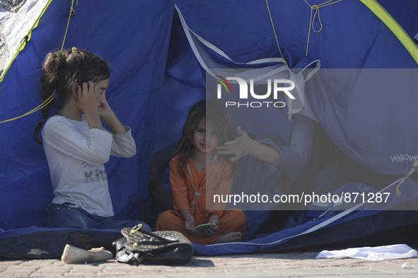 A young Fariba (age 3) from Afganistan, pictured in Kos harbour, as her family awaiting to be processed by the Greek police and given paperw...