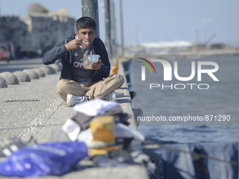 A migrant enjoys a meal he received from local volunteers, as awaiting in Kos harbour to be processed by the Greek police and given paperwor...