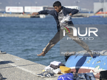 A migrant pictured in Kos harbour, as awaiting to be processed by the Greek police and given paperwork entitling them to leave the island....