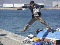 A migrant pictured in Kos harbour, as awaiting to be processed by the Greek police and given paperwork entitling them to leave the island....