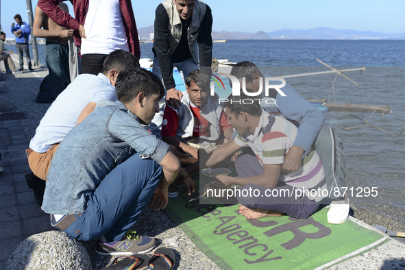 A group of migrants pictured in Kos harbour having their hot meals they received from local volunteers, as awaiting to be processed by the G...