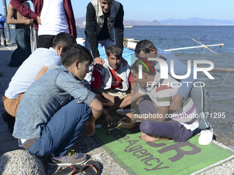 A group of migrants pictured in Kos harbour having their hot meals they received from local volunteers, as awaiting to be processed by the G...