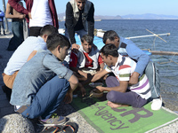 A group of migrants pictured in Kos harbour having their hot meals they received from local volunteers, as awaiting to be processed by the G...