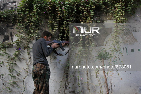 A fighter from the Free Syrian Army takes position following clashes with the pro-regime forces, in Bab al-hadid in the northern Syrian city...