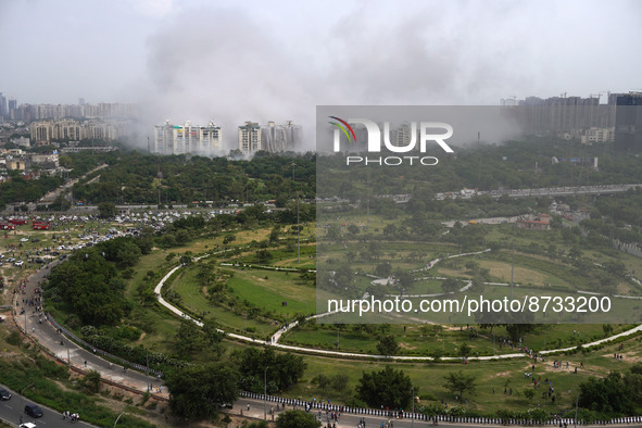 Nearby residential buildings are engulfed by dust as the Supertech Twin Towers collapse following a controlled demolition by explosion after...