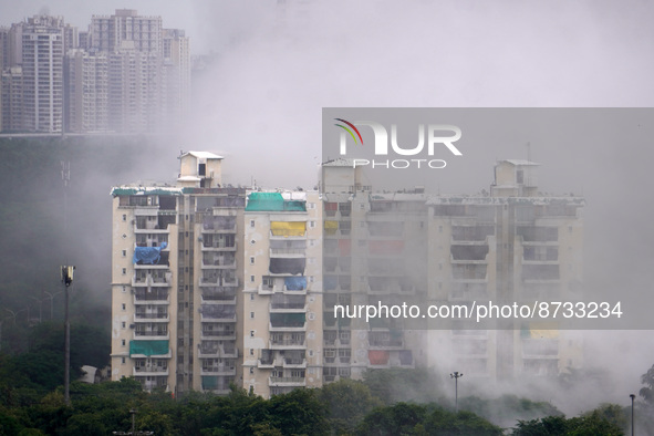 Balconies of nearby residential buildings are covered with plastic to block dust as the Supertech Twin Towers collapse following a controlle...