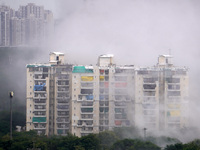 Balconies of nearby residential buildings are covered with plastic to block dust as the Supertech Twin Towers collapse following a controlle...