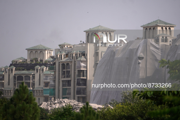 Debris is seen near residential buildings as the Supertech Twin Towers collapse following a controlled demolition by explosion after the Sup...