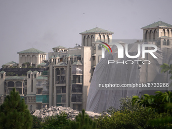 Debris is seen near residential buildings as the Supertech Twin Towers collapse following a controlled demolition by explosion after the Sup...