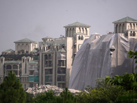 Debris is seen near residential buildings as the Supertech Twin Towers collapse following a controlled demolition by explosion after the Sup...