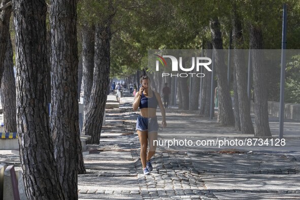 People are seen performing outdoor activities in the surroundings of the Tejo river promenade in Oriente. Lisbon, August 23, 2022. The manda...