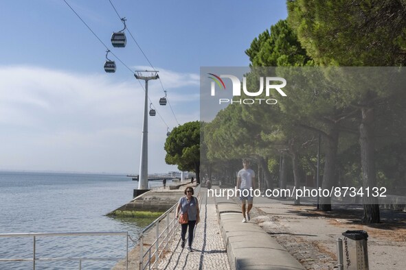 People are seen performing outdoor activities in the surroundings of the Tejo river promenade in Oriente. Lisbon, August 23, 2022. The manda...