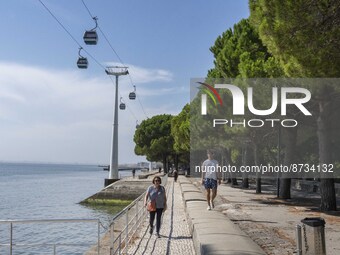 People are seen performing outdoor activities in the surroundings of the Tejo river promenade in Oriente. Lisbon, August 23, 2022. The manda...