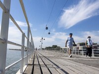 People are seen performing outdoor activities in the surroundings of the Tejo river promenade in Oriente. Lisbon, August 23, 2022. The manda...