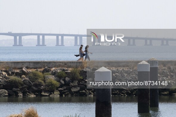 People are seen performing outdoor activities in the surroundings of the Tejo river promenade in Oriente. Lisbon, August 23, 2022. The manda...