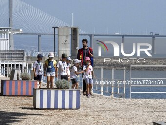 People are seen performing outdoor activities in the surroundings of the Tejo river promenade in Oriente. Lisbon, August 23, 2022. The manda...