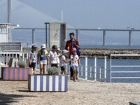 People are seen performing outdoor activities in the surroundings of the Tejo river promenade in Oriente. Lisbon, August 23, 2022. The manda...