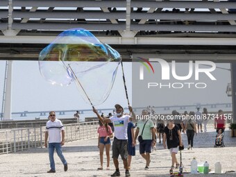 People are seen performing outdoor activities in the surroundings of the Tejo river promenade in Oriente. Lisbon, August 23, 2022. The manda...