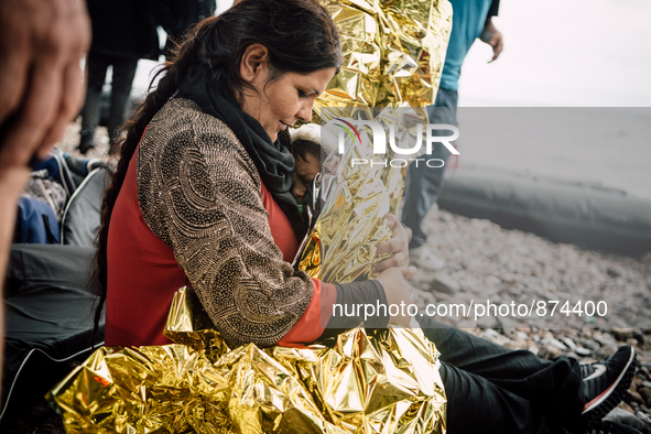 A women wraps her child in a thermal blanket after arriving on the shores of Lesbos, Greece, on September 28, 2015. More than 700,000 refuge...