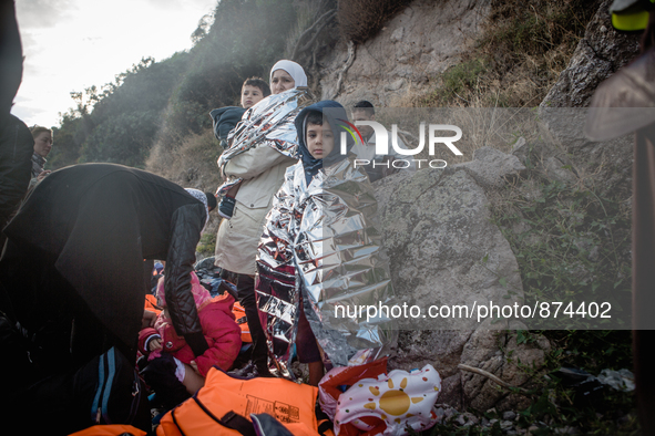 A young boy wraps himself in a termal blanket, in Lesbos, Greece, on September 29, 2015. More than 700,000 refugees and migrants have reache...