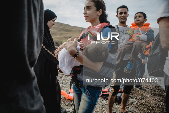 A young girl holds her brother after disembarking from a dingh from Turkey to Greece, in Lesbos, on September 26, 2015. More than 700,000 re...