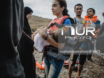 A young girl holds her brother after disembarking from a dingh from Turkey to Greece, in Lesbos, on September 26, 2015. More than 700,000 re...