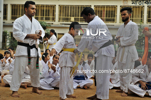 A Student receives a yellow belt during a martial arts class on the playground of a school in Dhaka, Bangladesh on August 30, 2022.  