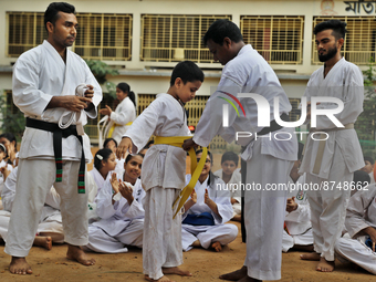 A Student receives a yellow belt during a martial arts class on the playground of a school in Dhaka, Bangladesh on August 30, 2022.  (