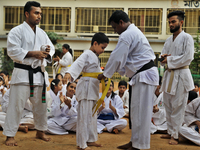 A Student receives a yellow belt during a martial arts class on the playground of a school in Dhaka, Bangladesh on August 30, 2022.  (