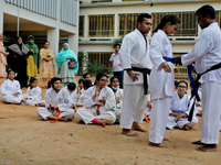 A Student receives a yellow belt during a martial arts class on the playground of a school in Dhaka, Bangladesh on August 30, 2022.  (