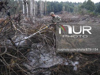 Rescuer extinguishes peat soil fires near the village of Sosnivka in the Kyiv Region, Ukraine September 6, 2022 (