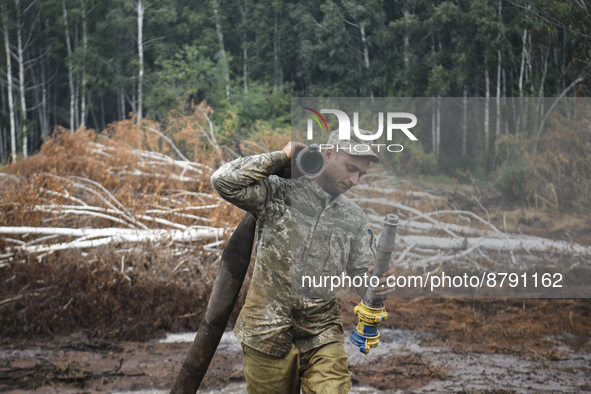 Rescuer extinguishes peat soil fires near the village of Sosnivka in the Kyiv Region, Ukraine September 6, 2022 