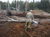 Rescuer extinguishes peat soil fires near the village of Sosnivka in the Kyiv Region, Ukraine September 6, 2022 (