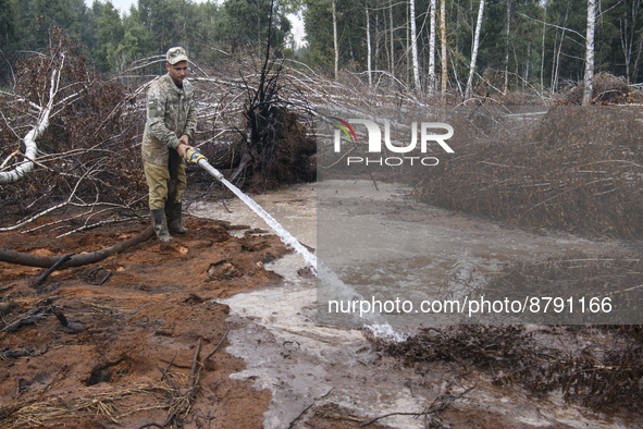 Rescuer extinguishes peat soil fires near the village of Sosnivka in the Kyiv Region, Ukraine September 6, 2022 