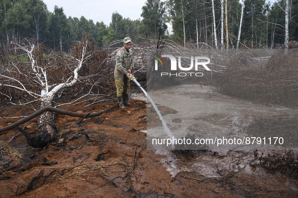 Rescuer extinguishes peat soil fires near the village of Sosnivka in the Kyiv Region, Ukraine September 6, 2022 